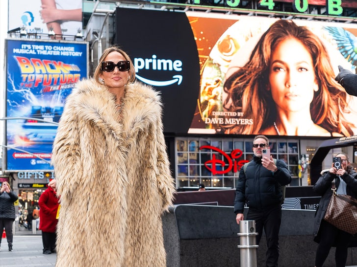 J Lo Poses In Entrance of Instances Sq. Billboards Selling Her New Album